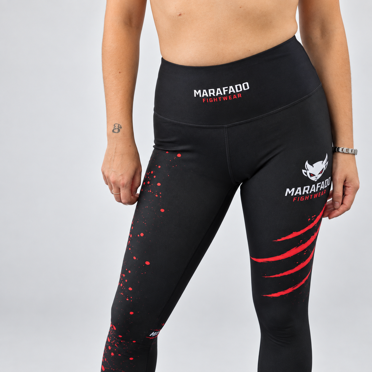Leggings Hard to Handle pretas e vermelhas da Marafado Fightwear, vestidas por modelo feminino, pormenor frontal da cintura alta, costuras e logótipos.